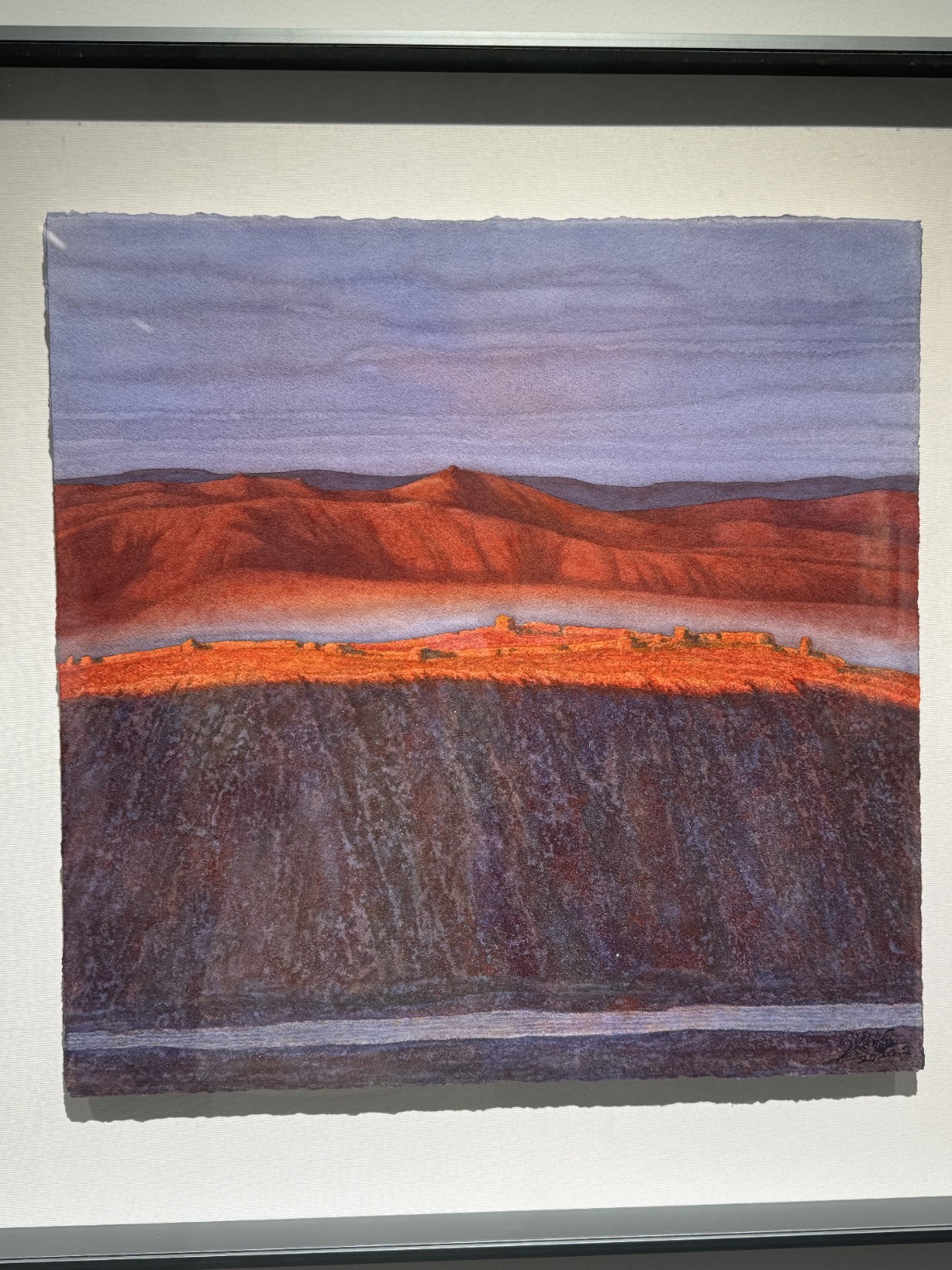 红土地观展照片:紫灰天空、红色山体、橙色窄带与深暗前景。