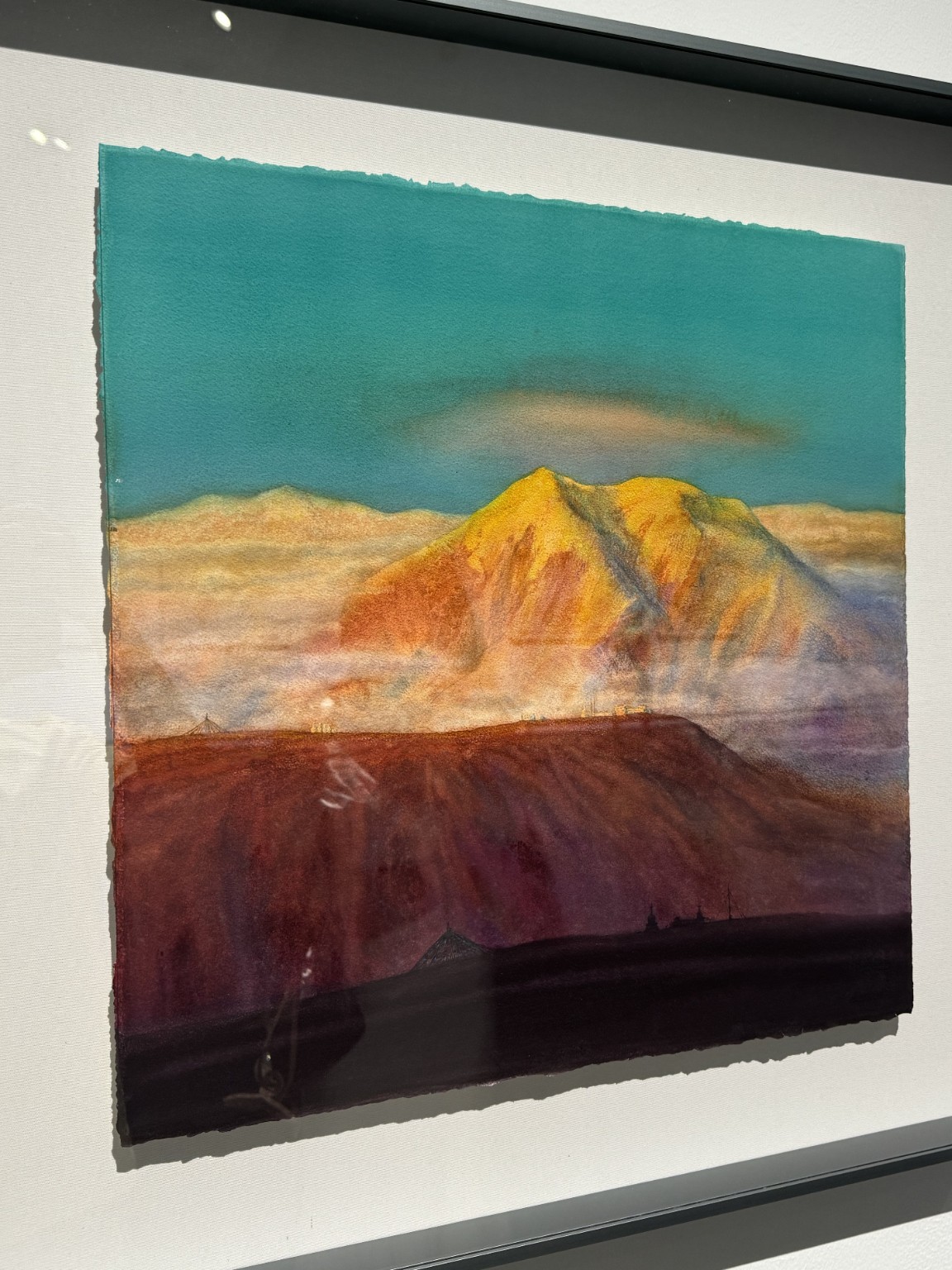 青绿天空、黄橙山体、浅色雾区与紫红前景的观展照片